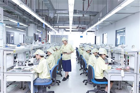 simsearch:649-07437205,k - Supervisor overseeing quality check station at factory producing flexible electronic circuit boards. Plant is located in the south of China, in Zhuhai, Guangdong province Stock Photo - Premium Royalty-Free, Code: 649-08238653