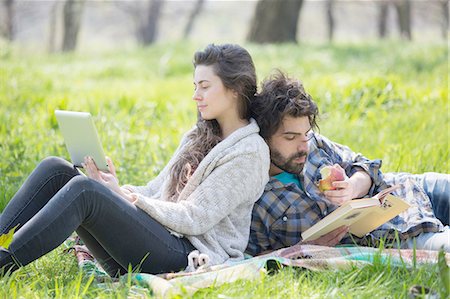 simsearch:649-07761246,k - Young couple back to back reading and using digital tablet in woodland Stock Photo - Premium Royalty-Free, Code: 649-08232494