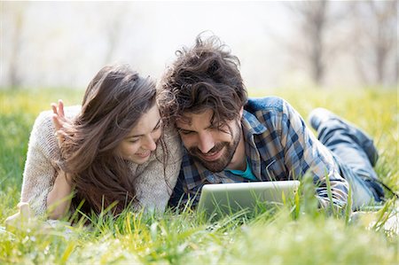 Young couple on picnic blanket browsing digital tablet Stock Photo - Premium Royalty-Free, Code: 649-08232496