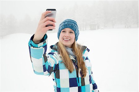 simsearch:614-08126589,k - Young woman taking selfie in snow, Sattelbergalm, Tirol, Austria Photographie de stock - Premium Libres de Droits, Code: 649-08232616