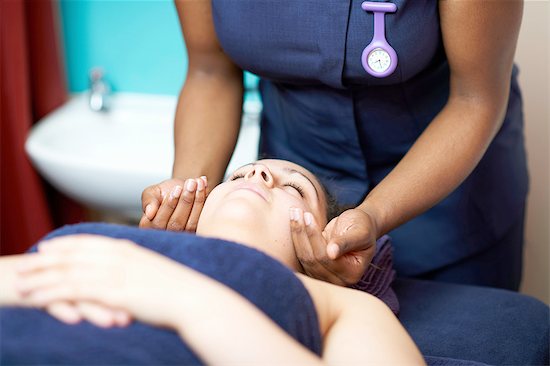 Head and shoulders of young woman lying down having facial massage, eyes closed Stock Photo - Premium Royalty-Free, Image code: 649-08232675