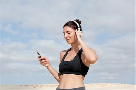 simsearch:649-08118826,k - Mid adult woman selecting music for headphones whilst exercising  at beach Foto de stock - Sin royalties Premium, Código: 649-08232725