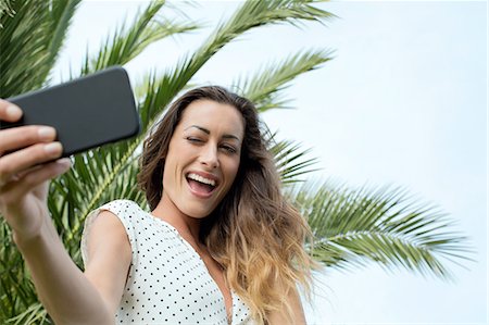 person winking - Young woman taking smartphone selfie Stock Photo - Premium Royalty-Free, Code: 649-08306377