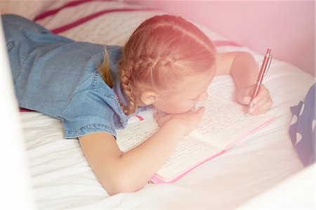 High angle view of girl lying on bed writing in notebook Photographie de stock - Premium Libres de Droits, Code: 649-08306396