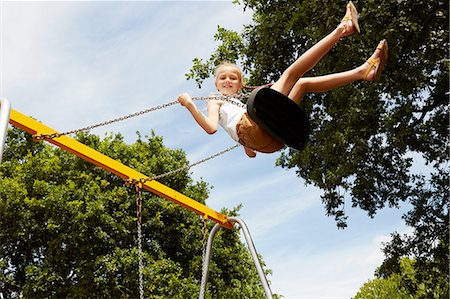 simsearch:649-08306424,k - Low angle view of girl on swing looking at camera smiling Photographie de stock - Premium Libres de Droits, Code: 649-08306428