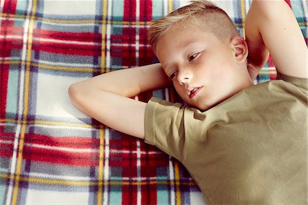 photography single boys person - High angle view of boy lying on picnic blanket hands behind head looking away Stock Photo - Premium Royalty-Free, Code: 649-08306422