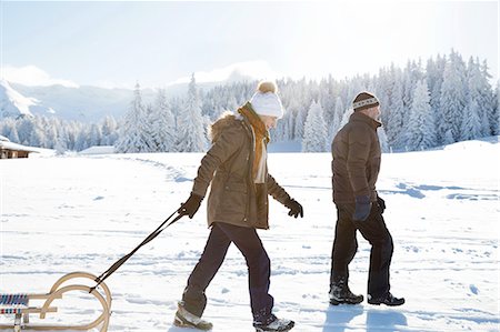 Side view of senior couple on snowy landscape pulling sledge, Sattelbergalm, Tyrol, Austria Foto de stock - Sin royalties Premium, Código: 649-08306447