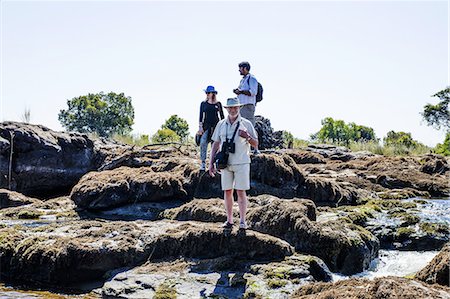 simsearch:649-07239718,k - Couple and mature man on rocks, near Victoria Falls, Zambia Stock Photo - Premium Royalty-Free, Code: 649-08306576