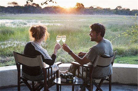 people africa two people - Couple making wine toast at sunset at safari lodge, Kafue National Park, Zambia Stock Photo - Premium Royalty-Free, Code: 649-08306600