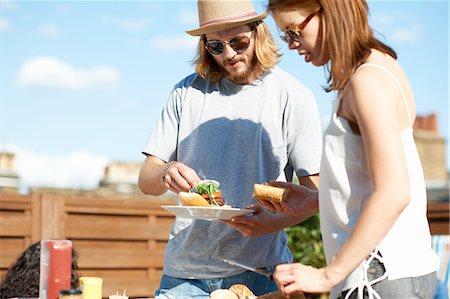 Couple eating and talking at rooftop party Stockbilder - Premium RF Lizenzfrei, Bildnummer: 649-08306624