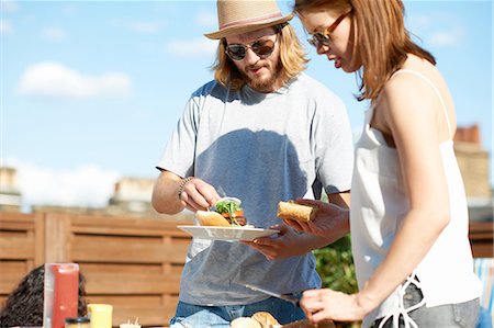 simsearch:649-08306619,k - Couple eating and talking at rooftop party Foto de stock - Sin royalties Premium, Código: 649-08306624