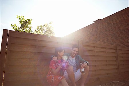 sitting fence - Relaxed mid adult couple chatting and drinking at rooftop party Stock Photo - Premium Royalty-Free, Code: 649-08306635