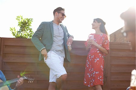 Mid adult couple chatting and drinking at rooftop party Foto de stock - Sin royalties Premium, Código: 649-08306633