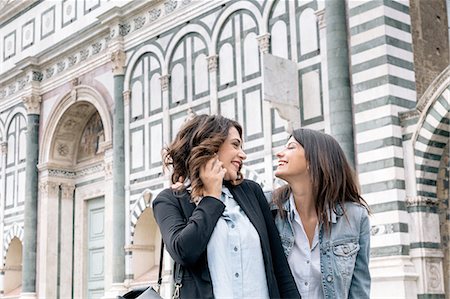 Lesbian couple using mobile phone face to face smiling, Piazza Santa Maria Novella, Florence, Tuscany, Italy Foto de stock - Sin royalties Premium, Código: 649-08306696