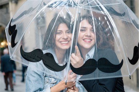 Lesbian couple underneath transparent umbrella looking at camera smiling, Florence, Tuscany, Italy Foto de stock - Royalty Free Premium, Número: 649-08306737