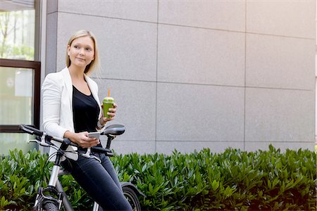 simsearch:6113-08171317,k - Young woman leaning against bicycle using smartphone Stock Photo - Premium Royalty-Free, Code: 649-08306786