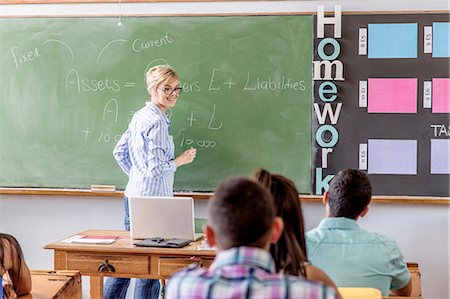 Female teacher addressing students in classroom Foto de stock - Sin royalties Premium, Código: 649-08306862