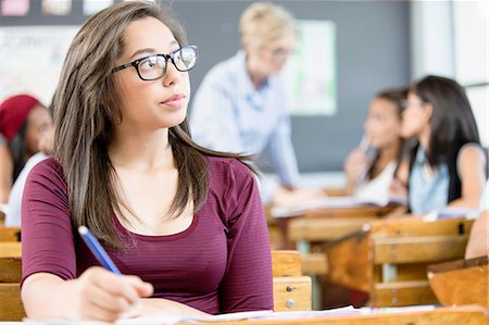 student daydreaming - Female student, sitting at desk in classroom, writing Stock Photo - Premium Royalty-Free, Code: 649-08306911