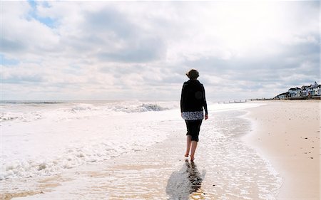 Mature woman, walking along beach, rear view Stock Photo - Premium Royalty-Free, Code: 649-08306933