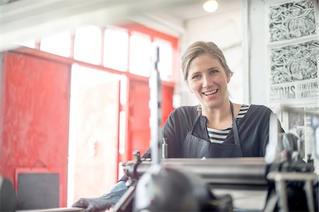 Portrait of female printer with traditional letterpress print machine in workshop Stock Photo - Premium Royalty-Free, Code: 649-08307046