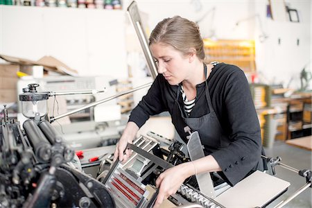 Female letterpress printer preparing print machine in workshop Stock Photo - Premium Royalty-Free, Code: 649-08307051