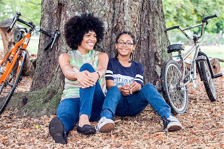 Portrait of mature woman and son sitting against park tree Stock Photo - Premium Royalty-Free, Code: 649-08307204