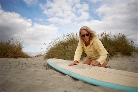simsearch:649-08307256,k - Senior woman on beach, waxing surfboard Fotografie stock - Premium Royalty-Free, Codice: 649-08307230
