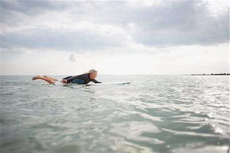 simsearch:649-08307252,k - Senior woman on surfboard in sea, paddleboarding Photographie de stock - Premium Libres de Droits, Code: 649-08307244