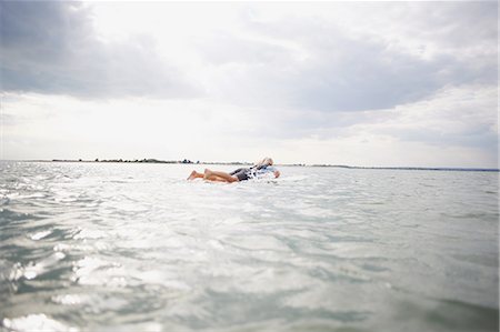 senior woman alone from behind - Senior woman on surfboard in sea, paddleboarding Stock Photo - Premium Royalty-Free, Code: 649-08307245