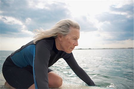 simsearch:649-08307252,k - Senior woman on surfboard in sea, paddleboarding Photographie de stock - Premium Libres de Droits, Code: 649-08307242