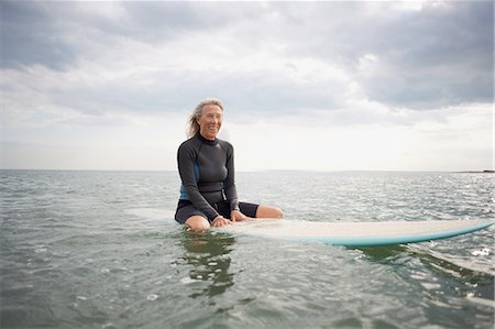 simsearch:649-08060114,k - Portrait of  senior woman sitting on surfboard in sea, smiling Foto de stock - Sin royalties Premium, Código: 649-08307243