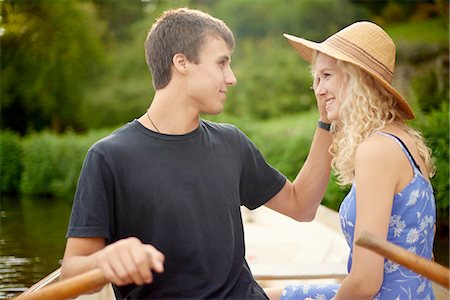 Romantic young couple rowing boat on rural river Stock Photo - Premium Royalty-Free, Code: 649-08307311