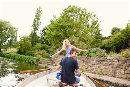 Rear view of young woman with boyfriend standing in rowing boat on river Stock Photo - Premium Royalty-Free, Code: 649-08307323