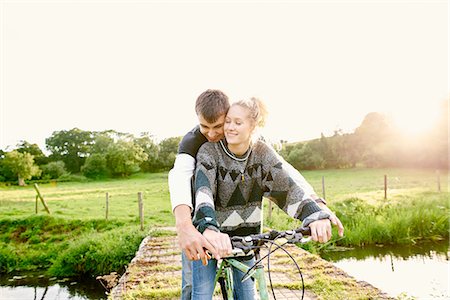 somerset - Young couple sharing bicycle at river footbridge Photographie de stock - Premium Libres de Droits, Code: 649-08307331