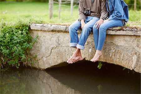 simsearch:649-08307314,k - Neck down view of young couple sitting on river footbridge Foto de stock - Sin royalties Premium, Código: 649-08307346