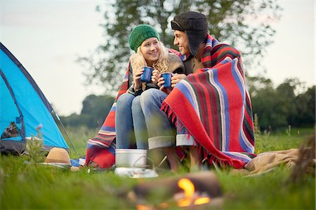 simsearch:649-08307314,k - Young camping couple sitting by campfire with cup of tea Foto de stock - Sin royalties Premium, Código: 649-08307353