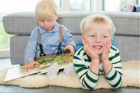 simsearch:649-08307462,k - Male toddler reading childrens book on living room floor Fotografie stock - Premium Royalty-Free, Codice: 649-08307445