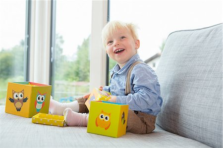 Portrait of happy male toddler playing with building blocks on sofa Photographie de stock - Premium Libres de Droits, Code: 649-08307448