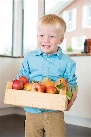 Portrait of boy holding crate of apples Stock Photo - Premium Royalty-Free, Code: 649-08307457