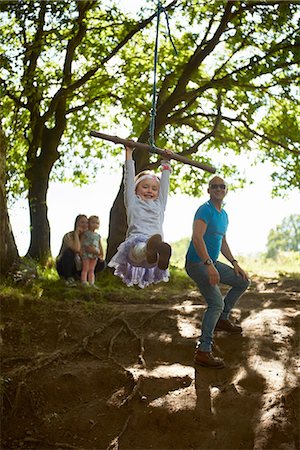 simsearch:649-07280283,k - Young girl swinging on tree swing while her family watch Stock Photo - Premium Royalty-Free, Code: 649-08327687