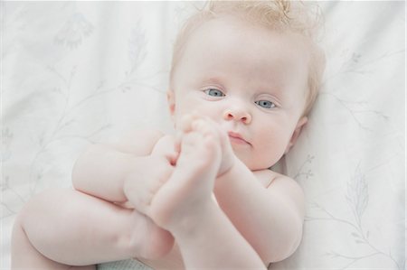 Baby girl, lying on back, holding feet Photographie de stock - Premium Libres de Droits, Code: 649-08327700