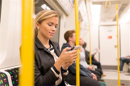 Businesswoman texting on tube, London Underground, UK Stock Photo - Premium Royalty-Free, Code: 649-08327763