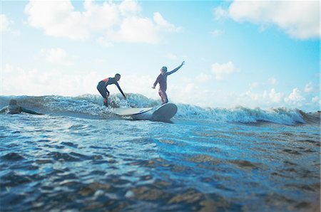 Two surfers surfing in sea Photographie de stock - Premium Libres de Droits, Code: 649-08327896