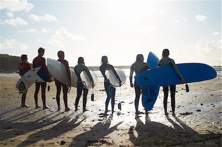 simsearch:649-02054536,k - Group of surfers, standing on beach, holding surfboards, rear view Stock Photo - Premium Royalty-Free, Code: 649-08327891