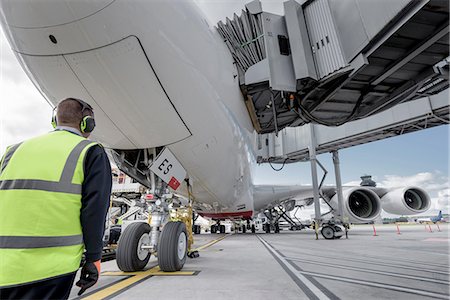 pista de aterrizaje - Engineer inspecting A380 aircraft at stand in airport Foto de stock - Sin royalties Premium, Código: 649-08327965