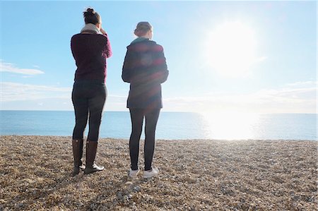 simsearch:649-08125388,k - Rear view of two young adult sisters looking out at sunlit sea Stock Photo - Premium Royalty-Free, Code: 649-08328014