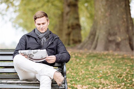 reading on park bench - Young man reading newspaper on park bench Stock Photo - Premium Royalty-Free, Code: 649-08328041