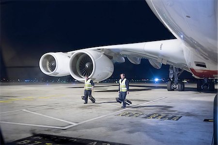 Ground crew removing wheel chocks from A380 aircraft at night Stock Photo - Premium Royalty-Free, Code: 649-08328177