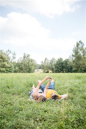 simsearch:649-08328214,k - Young couple lying on grass in field, taking self portrait using smartphone Foto de stock - Royalty Free Premium, Número: 649-08328227