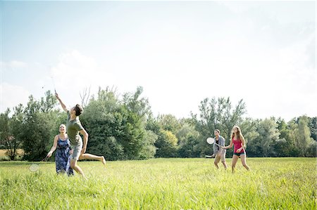simsearch:649-08328214,k - Group of young adults playing badminton in field Foto de stock - Royalty Free Premium, Número: 649-08328221